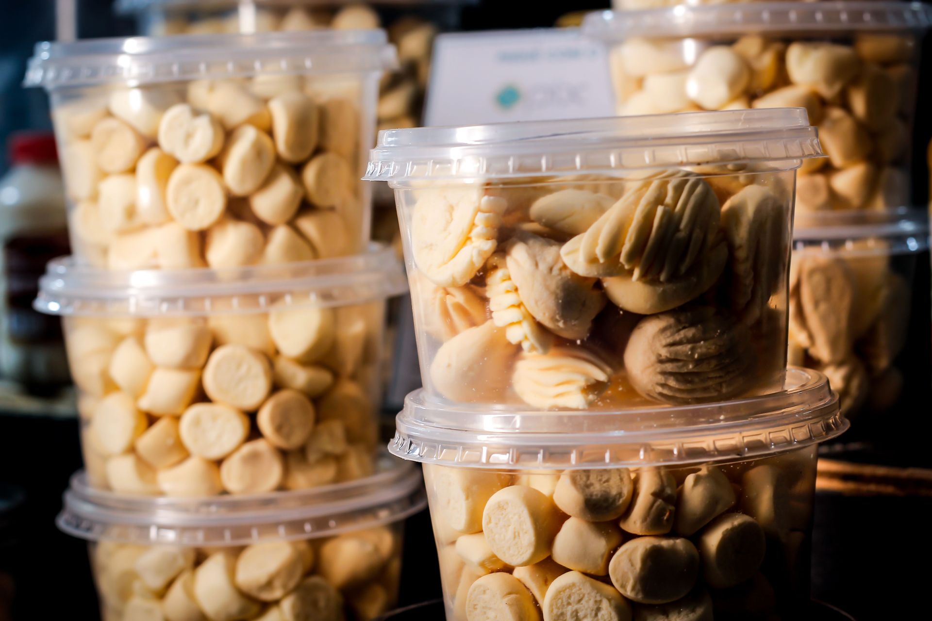 Close-up of plastic containers filled with homemade cookies in a store setting.